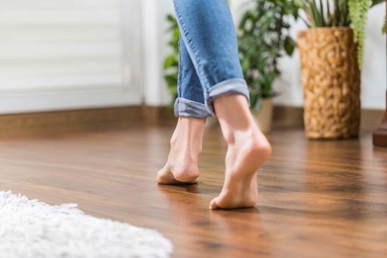 Füße gehen auf Boden mit Fußbodenheizung